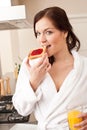Woman eating toast in kitchen Royalty Free Stock Photo