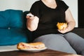 Woman eating tons of unhealthy food watching TV