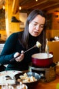 Woman eating tradicional Swiss dish - fondue Royalty Free Stock Photo
