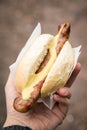 Woman eating typical grilled German Bratwurst sausage street food with bread roll bun and mustard on the go Royalty Free Stock Photo