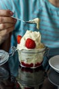 Woman eating vanilla ice cream with strawberry sauce served in a jar Royalty Free Stock Photo