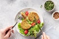 woman eating vegan broccoli and quinoa burgers