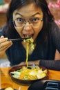 Woman eating yakisoba looking toward camera Royalty Free Stock Photo