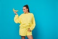 Woman eating yellow bananas in ears on blue background Royalty Free Stock Photo