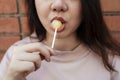 Woman eating yellow lollipop background