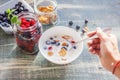 A woman is eating yogurt with cereal and berries for breakfast, Royalty Free Stock Photo