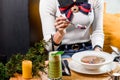 Woman eats broth with quail eggs, herbs, carrots and other vegetables in a white plate on a yellow set on the table. Royalty Free Stock Photo