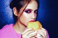 Woman eats a burger, food. Food porn. Teen girls enjoying delicious burgers in cafe. Beautiful young girl in studio on Royalty Free Stock Photo