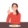 Woman eats french fries without thinking about health risks of fast food and fried snacks. Girl is having lunch in cafe sitting at