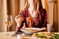Woman eats Italian pasta with tomato, meat. Close-up spaghetti Bolognese wind it around a fork with a spoon. Parmesan Royalty Free Stock Photo