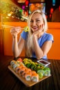 Woman eats traditional sushi rolls. Royalty Free Stock Photo