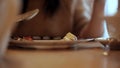 Woman eats vegetable and meat in cafe