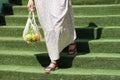 Woman with an eco-friendly shopping bag comes down the stairs from the store Royalty Free Stock Photo