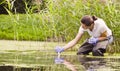 Woman ecologist measuring pH of the water