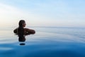 Woman at edge of infinity swimming pool with sea view Royalty Free Stock Photo