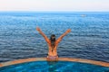 Woman at edge of infinity swimming pool with sea view Royalty Free Stock Photo