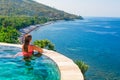 Woman at edge of infinity swimming pool with sea view Royalty Free Stock Photo