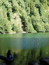 Woman at the edge of Logoa do Congro Lake on the island of Sao Miguel in the Azores