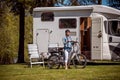 Woman on electric bike resting at the campsite VR Caravan car Va