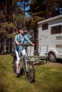 Woman on electric bike resting at the campsite VR Caravan car Va Royalty Free Stock Photo