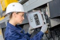 Woman electrician engineer inspecting electric counter utdoors