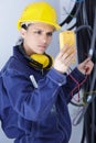 Woman electrician using digital meter to measure voltage Royalty Free Stock Photo