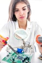 Woman Electronic Technician Repair Electronic Equipment using Electric Soldering Iron