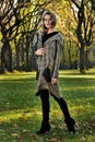 Woman in elegant design coat walking outdoor against an autumn nature landscape Royalty Free Stock Photo