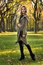 Woman in elegant design coat walking outdoor against an autumn nature landscape Royalty Free Stock Photo