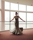 Woman, elegant dress and dancing in hallway, fashion and classy garment in lobby for event. Female person, twirl and Royalty Free Stock Photo