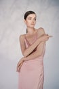 Beautiful woman pose in studio in pink classic dress