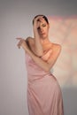 Beautiful woman pose in studio in pink classic dress