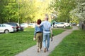 Woman in an embrace with a man who is holding beer bottles walking down the street in the spring. Moscow Royalty Free Stock Photo