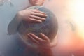 Woman embracing the globe of planet Earth. The concept of preserving the environment and love for your planet. Tint red and grey.