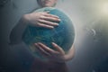 Woman embracing the globe of planet Earth. The concept of preserving the environment and love for your planet. Tint and loght.