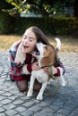 Woman embracing puppy dog outdoor. Happy girl gets lovely dog, plays and embraces. Humans and dogs. Royalty Free Stock Photo