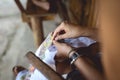 Woman embroider a serviette on knee.