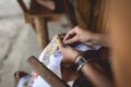 Woman embroider a serviette on knee.