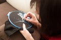 Woman embroiders a cross-stitch image on fabric