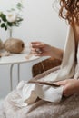 Woman embroidery on fabric sitting in an armchair