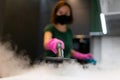 Woman employee cleaning company blows vapor out of steam generator. Steam cleaning process for kitchen furniture.