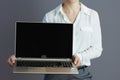 Woman employee showing laptop blank screen isolated on grey Royalty Free Stock Photo