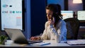 Woman employee speaking at phone while working at laptop Royalty Free Stock Photo