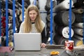 Woman employee of a textile warehouse at her work place. She is using a laptop