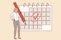 Woman is engaged in business planning and uses calendar to keep schedule, standing with large pencil Royalty Free Stock Photo