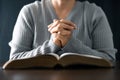 Woman engaged in prayer. In the quiet darkness of a sacred room, she seeks solace, spiritual connection. Immerse yourself in the Royalty Free Stock Photo