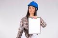 A woman engineer in a blue hardhat, shows a folder file for your advertisment on a white background