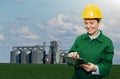 Woman engineer with a digital tablet on a background of agricultural silos Royalty Free Stock Photo