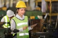 Woman engineer in full safety equipment is working and inspecting inside the heavy industrial factory using tablet Royalty Free Stock Photo