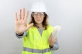 Woman engineer with hardhat and reflecting jacket with open hand doing stop sign with serious and confident expression Royalty Free Stock Photo